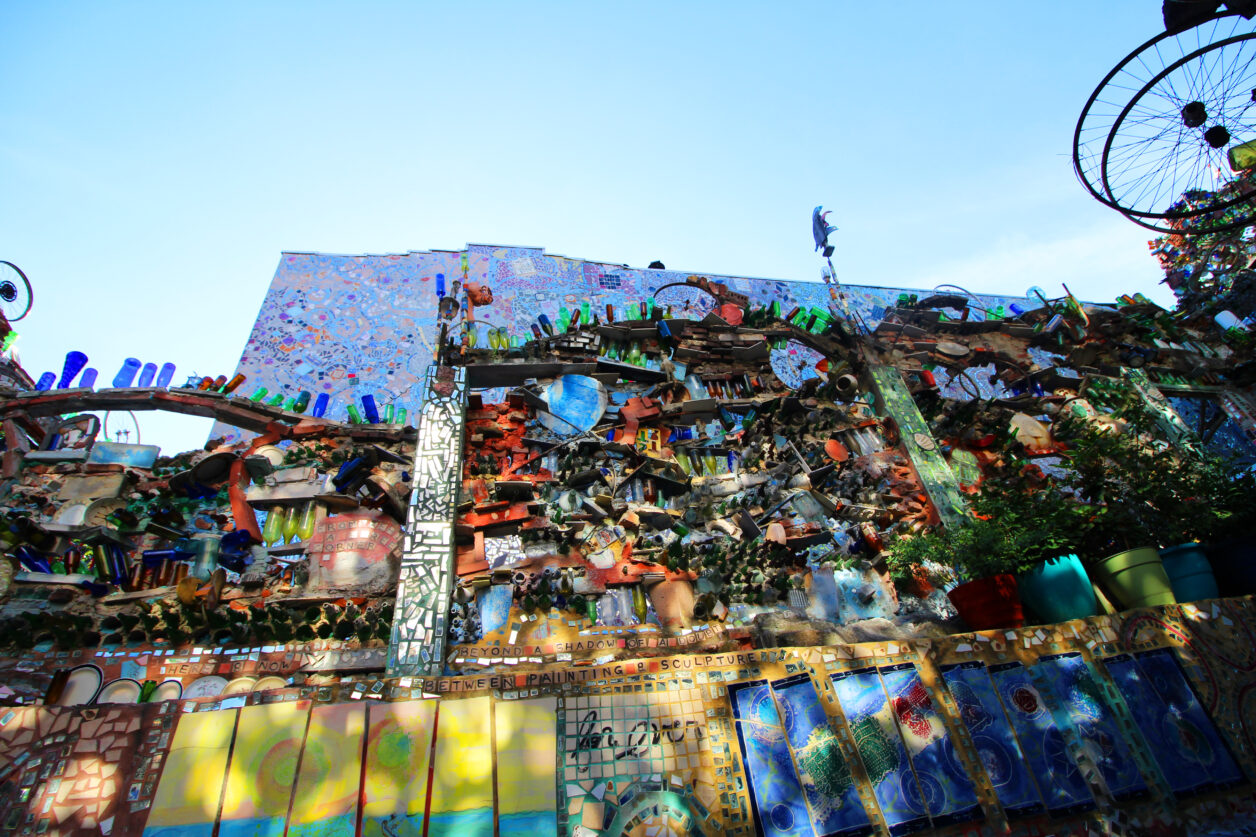 Looking up at a two-story mosaicked wall outside at Philadelphia's Magic Gardens.