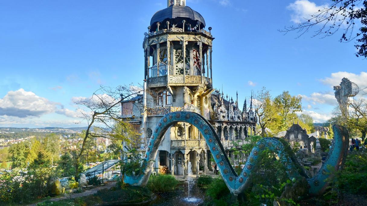 A towering building with a large tiled snake in front of it.