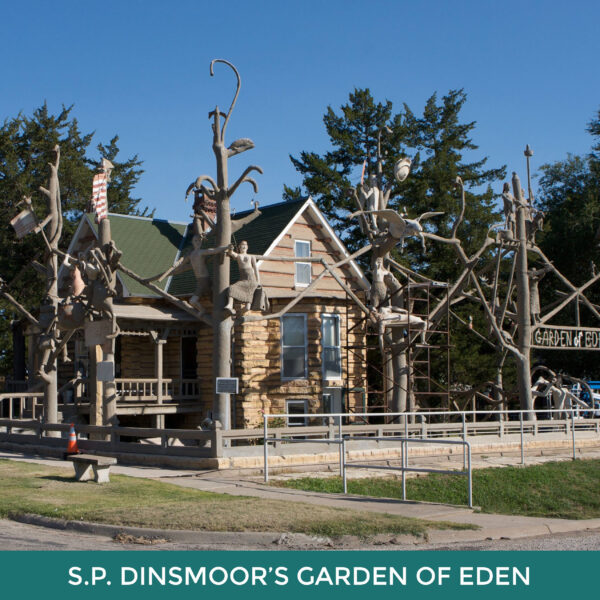 S.P. Dinsmoor’s The Garden of Eden. A home that looks like it's made of wooden logs surrounded by tall cement sculptures. 