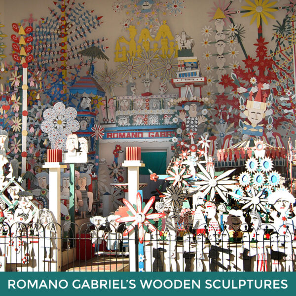 Romano Gabriel’s Wooden Sculpture Garden. A group of carved and painted wooden sculptures in the shapes of people and flowers. 