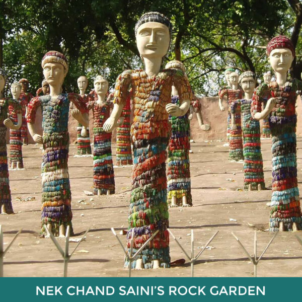 Nek Chand Saini’s Rock Garden, statues of people standing equally spaced apart. They wear colorful mosaicked clothing.