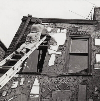 A black and white photo of Isaiah Zagar in 1968 mosaicked the back of the Eye's Gallery building.