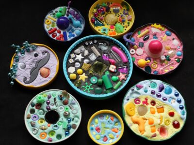 Jar lids filled with colorful beads, bits of rock, glass, and grout