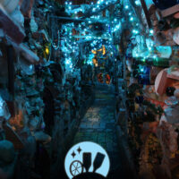 A sculptural hallway outside at Philadelphia's Magic Gardens illuminated by blue lights.