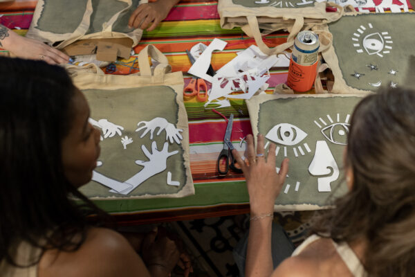 Two people place objects on a surface treated with light-sensitive chemicals