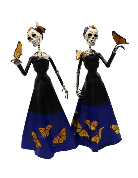 Two papier mache skeletons wearing long blue and black dresses, holding butterflies
