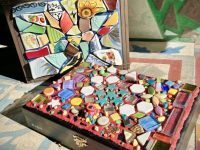 Two cigar boxes with colorful tile mosaics on the top.