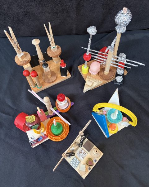 Six sculptures made of found objects like popsicle sticks, bottle caps, clothespins, and tinfoil.